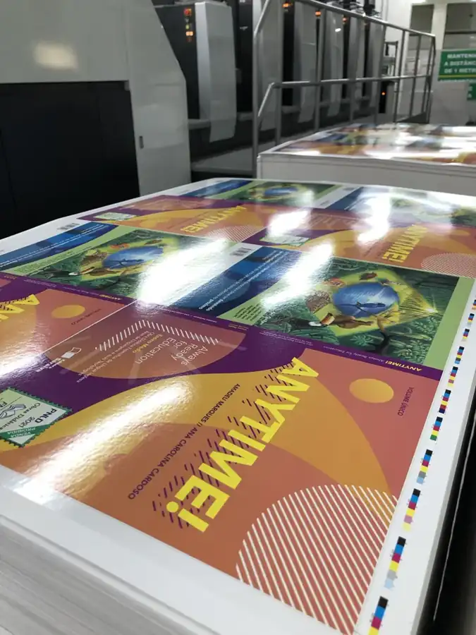 Pilha de folhas impressas com várias capas montadas e barra de controle de cor na lateral